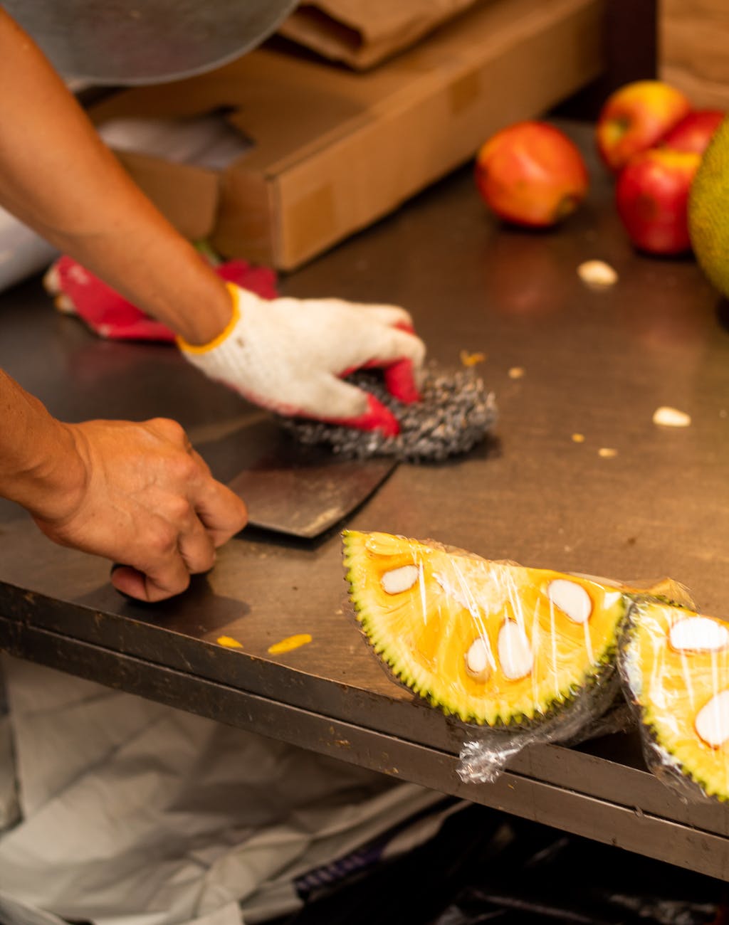 sliced yellow fruit near a person cleaning the knife