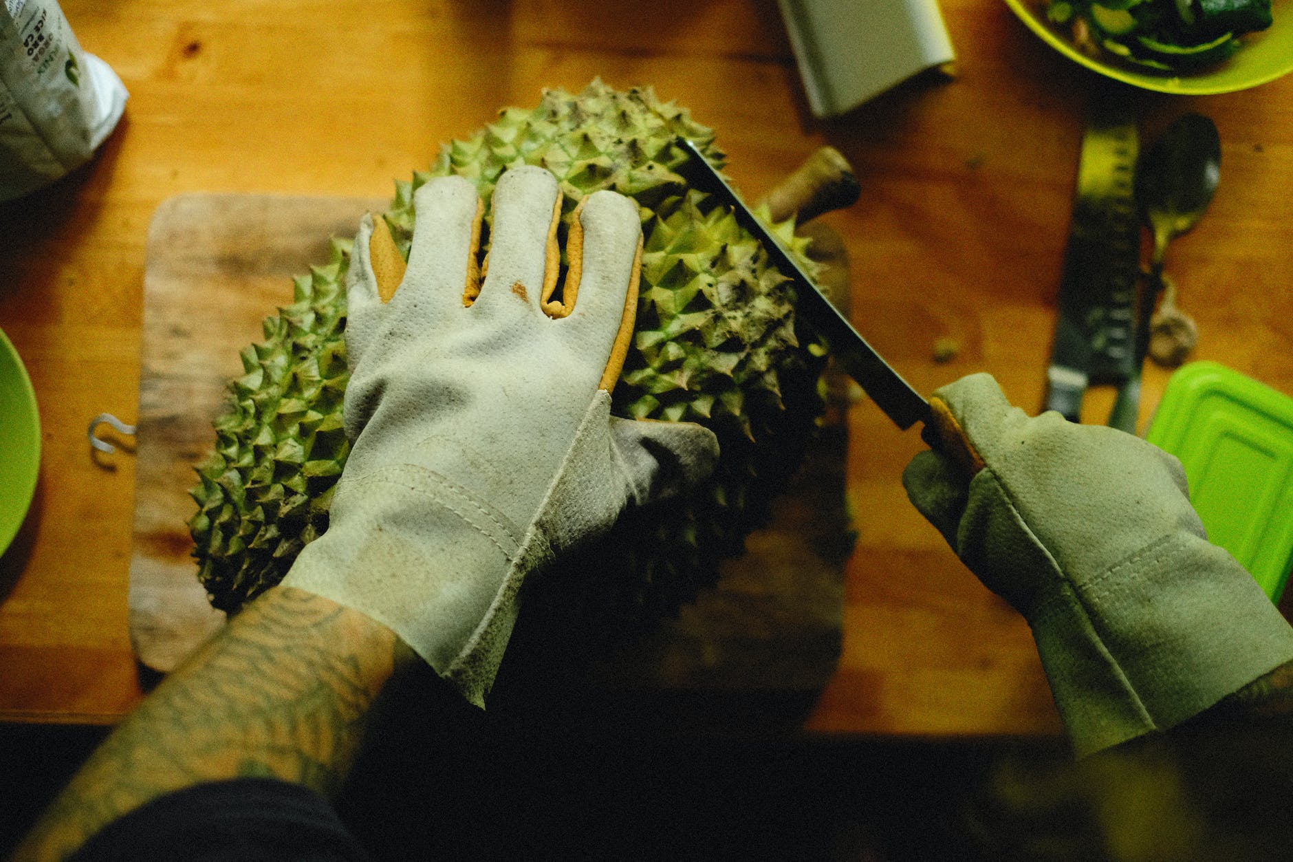 a person cutting a spiny fruit