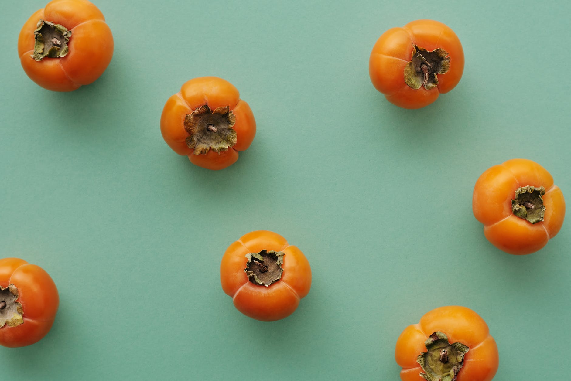 orange persimmons on blue surface