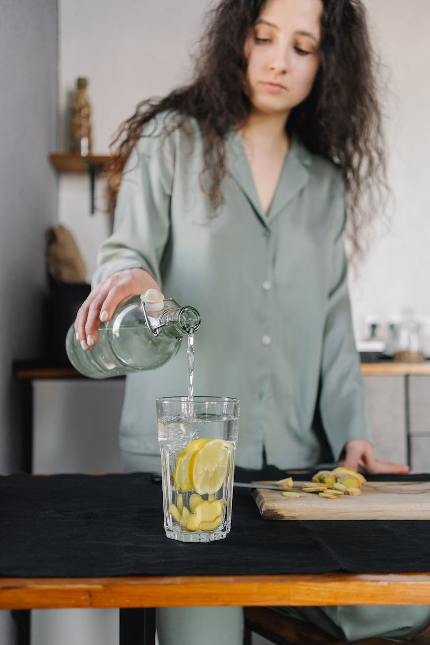 a woman making a ginger lemon drink