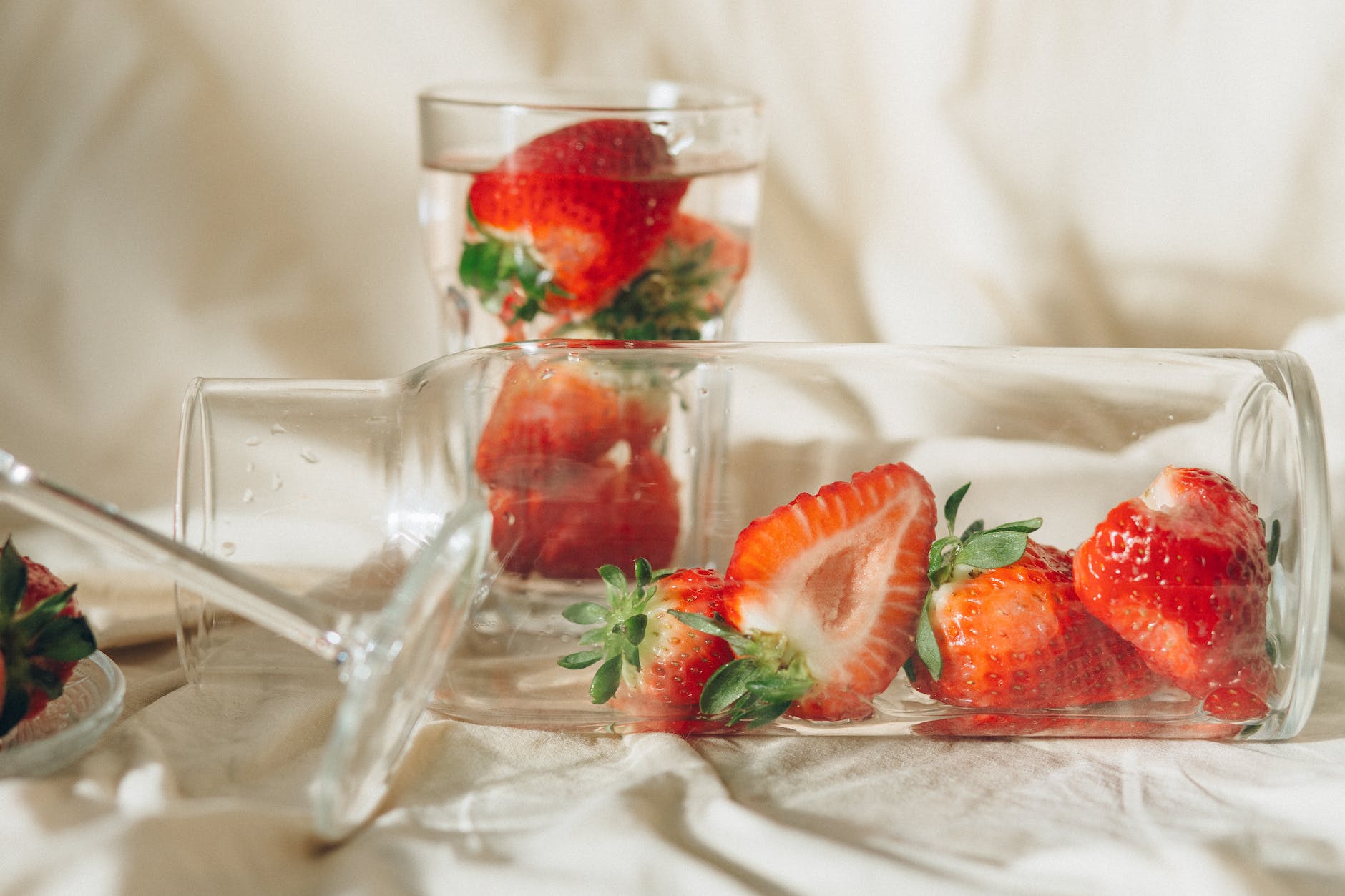 close up photo of sliced strawberries in clear glass jar