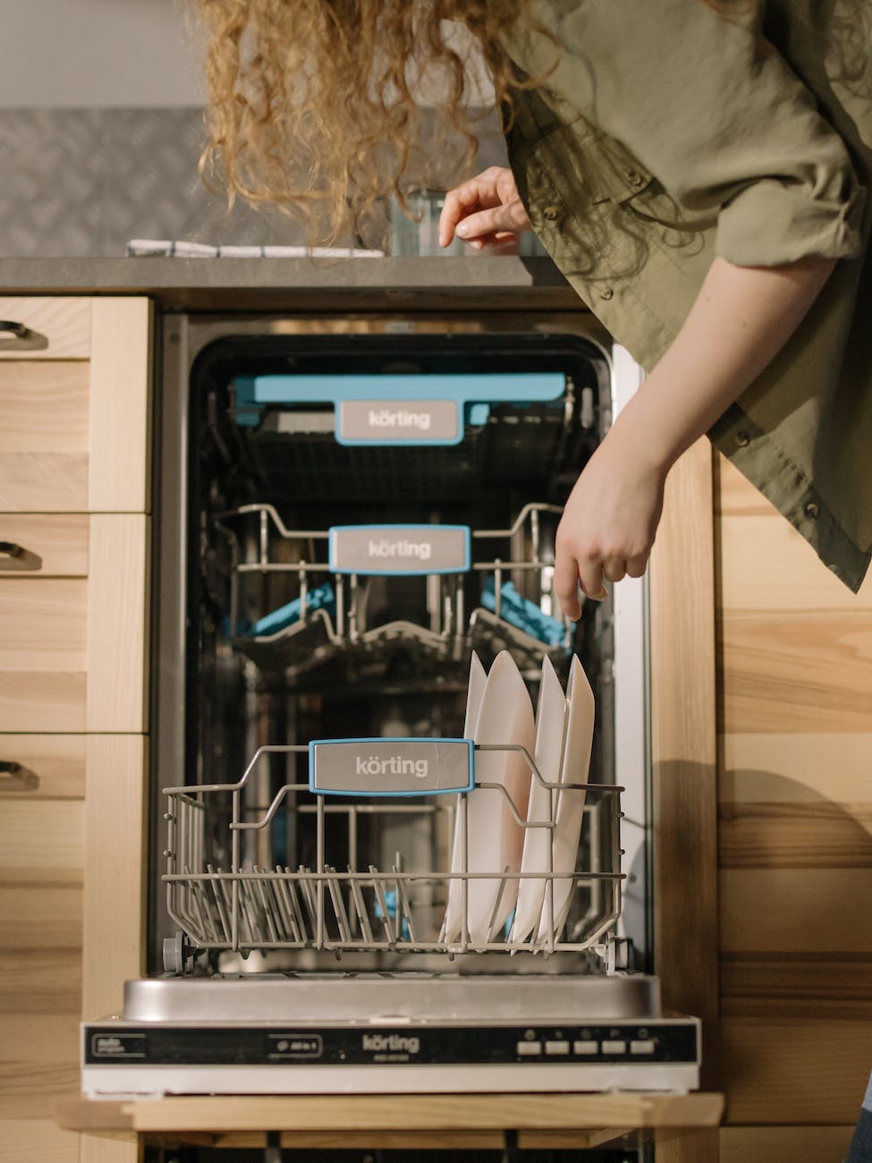 person using dishwasher for cleaning plates